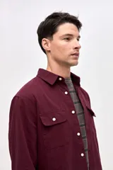 Sobrecamisa de algodón color bordó, con cuello solapa, cierre frontal con botones y dos bolsillos en el pecho con tapa.