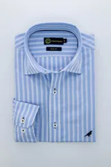 Camisa de vestir manga larga, corte slim fit, con cuello americano y estampado a rayas verticales celestes y blancas.