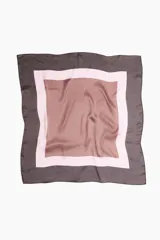 Pañuelo de tejido suave con diseño de bloques de color en tonos marrón oscuro, rosa claro y marrón claro.