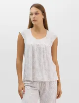 Pijama compuesto por remera sin mangas con escote redondo, botones frontales y detalle de puntilla, acompañado de un pantalón capri con cintura elástica. Presenta un estampado floral en tonos rosados sobre base gris.