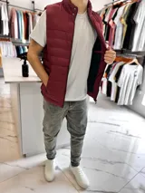 Chaleco puffer de nylon color bordó, con cuello alto, cierre frontal y bolsillos. Cuenta con un parche redondo con la inscripción "TURK" en el pecho.