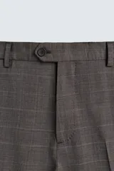 Pantalón de traje de corte regular fit, confeccionado en lana de origen italiano. Presenta un diseño a cuadros sutiles, bolsillos delanteros, bolsillos traseros de doble vivo con botón y cierre frontal con cremallera y botón.