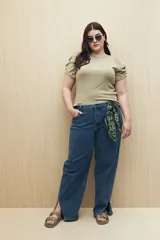 Jean de corte recto confeccionado en denim con spandex, de tiro medio y color azul clásico. Presenta tajos laterales en el ruedo y cierre frontal con botón y cremallera.