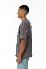 Remera gris a rayas horizontales blancas y azules, con cuello redondo azul y logo 'Vernal' bordado en azul. Corte holgado.