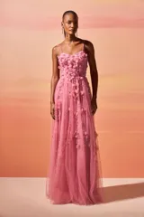 Vestido largo de fiesta color rosa, con cuerpo tipo corsé y falda de tul con caída fluida. Presenta flores en 3D y bordados artesanales en el escote y el torso, con breteles finos.