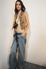 Chaleco color arena con bordados florales en hilo dorado y cuentas negras.