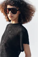 Top de punto pointelle color negro, con cuello redondo y mangas cortas anchas de diseño holgado.