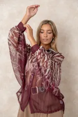 Camisa oversize de gasa con estampado de cadenas en tonos bordó y rosado. Presenta cuello clásico, cierre frontal con botones y mangas largas con puños abotonados.