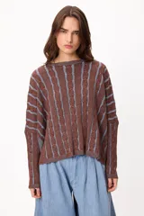 Sweater de punto con diseño de rayas verticales en relieve y textura trenzada, color terracota y beige. Presenta cuello redondo, corte holgado y diseño cropped.