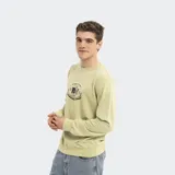 Buzo de cuello redondo marca Reef, color verde claro con efecto lavado. Presenta un estampado gráfico central con el logo de la marca y detalles en tonos oscuros.