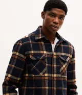 Campera trucker Marfinno para hombre de franela a cuadros en tonos azul marino, marrón y beige, con cuello inglés, cierre frontal de botones, bolsillos en el pecho con solapa, bolsillos laterales y forro interno de sherpa.