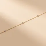 Pulsera de cadena fina en oro 18k con engarces de circonias distribuidas a lo largo de la pieza.