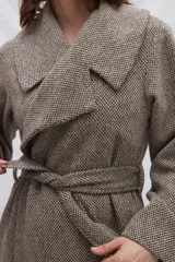 Tapado largo de lana con cuello solapa, cierre cruzado y cinto ajustable a la cintura. Presenta un diseño de textura jaspeada en tonos neutros.