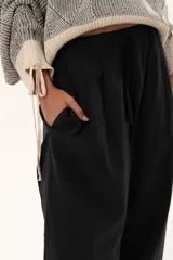 Pantalon de corte holgado y estilo relajado, confeccionado en color negro, con cintura elástica y cordón ajustable.