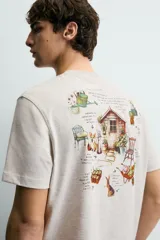 Camiseta de corte relajado, color gris jaspeado, con cuello redondo y manga corta. Presenta un parche rectangular azul marino en el centro del pecho con texto estampado en blanco y una frase adicional debajo.