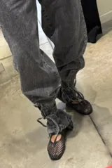 Jean de corte holgado en color gris con efecto lavado, caracterizado por sus lazos ajustables en los tobillos.