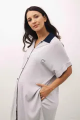 Camisa maternal de viscosa suave y liviana, con estampado de rayas verticales amarillas y blancas. Presenta cuello camisero, mangas cortas y bolsillos prácticos.