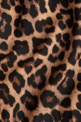 Vestido midi con estampado de leopardo, cuello camisero, manga corta y botonadura frontal. Presenta elástico en la cintura y cinturón extraíble para atar.