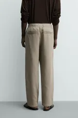 Pantalón de corte regular fit confeccionado en tejido mezcla de algodón, con cintura elástica ajustable mediante cordón, bolsillos laterales y bolsillos traseros de vivo.
