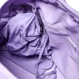 Bolso deportivo de gran capacidad en color lila, confeccionado en material textil con acabado arrugado. Cuenta con doble asa superior, correa ajustable y desmontable, y compartimento principal con cierre doble. Incluye correas en la base para sujetar accesorios y una bolsa interior desmontable.
