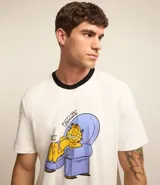 Conjunto de pijama para hombre, compuesto por remera de algodón color crudo con cuello redondo, mangas cortas y estampado de Garfield en un sillón, y short negro de algodón con cintura elástica.