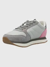 Zapatillas casuales de diseño contemporáneo, confeccionadas en una combinación de cuero y material textil. Presentan una base en tonos grises con detalles en rosa en el talón y suela dentada de goma en color marrón.