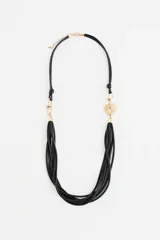 Collar largo negro con múltiples tiras de poliuretano, detalles metálicos dorados y un dije de corazón dorado texturizado. Cierre de mosquetón con cadena de extensión.