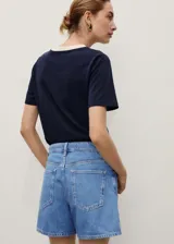 Short de denim azul medio, de tiro alto y diseño recto con cinco bolsillos, trabillas para cinto y cierre frontal con cremallera y botón.