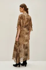 Vestido largo de estilo envolvente con estampado animal print, confeccionado en tejido fluido y ligero. Presenta escote en V, mangas tipo kimono amplias y lazo ajustable en la cintura que permite entallar la silueta. Incluye una abertura frontal en la falda.