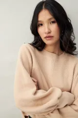 Sweater color beige de tejido de punto con mangas abullonadas y puños elastizados.