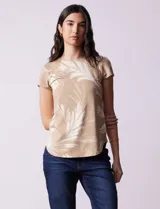 Remera color beige con estampado de hojas blancas, cuello redondo y mangas cortas.