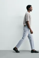 Jeans regular fit de denim de algodón en color gris con efecto lavado, tiro medio, diseño de cinco bolsillos y cierre frontal con botones.