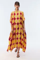 Kaftan maxi amplio de color amarillo, con escote redondo, mangas cortas y ruedo irregular. Presenta un diseño estampado a cuadros con efecto teñido.