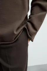 Sudadera tipo hoodie de corte relajado, confeccionada en tejido de algodón con interior de rizo. Presenta cuello con capucha, manga larga y acabados con bordes enrollados.