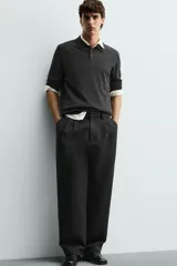 Pantalón de corte wide fit confeccionado en tejido con mezcla de lyocell. Presenta pliegues frontales dobles, bolsillos laterales y bolsillos traseros de vivo. Cierre frontal con cremallera y gancho metálico oculto.