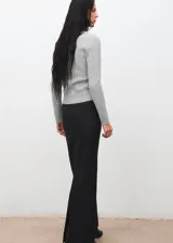 Cardigan de punto trenzado en color gris, con cuello en pico, manga larga y cierre frontal con botones.