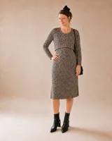 Vestido midi de punto acanalado en color beige, con cuello redondo, mangas largas y aberturas laterales en el ruedo. Presenta un diseño recto con apertura frontal oculta para lactancia.