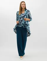 Conjunto de tres piezas compuesto por una musculosa de escote redondo, un saco largo abierto de mangas 3/4 y un pantalón palazzo de pierna ancha. La musculosa y el saco presentan un estampado abstracto de pinceladas en tonos azules con hilos metalizados, mientras que el pantalón es de color azul petróleo liso.