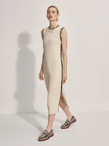 Vestido midi tejido color crema con ribete negro en cuello, sisas y ruedo. Presenta aberturas laterales en el ruedo.