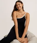 Vestido midi negro ajustado al cuerpo, confeccionado en tejido rib de viscosa. Presenta un diseño asimétrico con un solo hombro descubierto y un bretel con viés contrastante blanco en el escote. Posee un tajo lateral pronunciado.