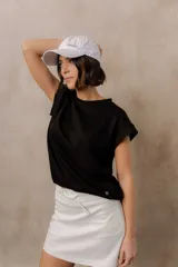 Sweater de punto color blanco, de corte relajado, con cuello redondo, manga corta japonesa de hombro caído y pretina ancha en la cintura.