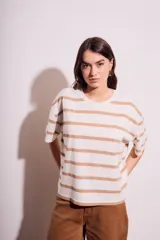 Remera de algodón color crudo con rayas horizontales color café, de corte oversize y mangas cortas.