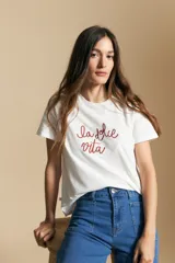 Remera blanca de manga corta con la frase "la dolce vita" bordada en rojo en el frente. Tiene un calce relajado.