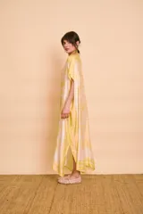 Vestido midi amarillo y blanco con estampado de paisajes y detalles de rayas en el cuello y el dobladillo, de corte holgado, mangas cortas y lazo ajustable en la cintura.