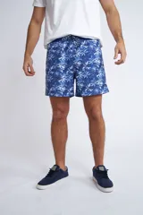 Short de baño con cintura elástica y cordón ajustable, confeccionado en tela ligera de secado rápido. Presenta un estampado botánico integral en tonos amarillos, blancos y azules, con dos bolsillos delanteros y uno posterior.