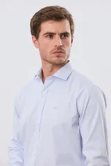 Camisa de vestir de manga larga con diseño de rayas finas celestes y blancas, cuello clásico y cierre frontal con botones. Incluye pequeño logo bordado en el pecho.