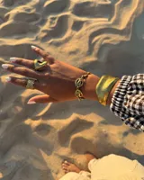 Pulsera de diseño artesanal elaborada eslabón por eslabón a mano, con eslabones circulares texturados de metal dorado y cadena regulable.