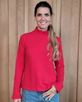 Polera de manga larga color rojo, con cuello alto con detalle de volados y puños con volados.