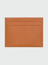 Tarjetero de cuero granulado color caramelo, con múltiples ranuras para tarjetas. Presenta el logo de Longchamp grabado en el centro.