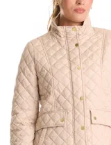 Campera de abrigo liviano con diseño capitoneado a rombos, cuello alto tipo mao y cierre frontal con solapa de botones a presión dorados. Presenta bolsillos frontales de parche con solapa y trabas de ajuste en la cintura.